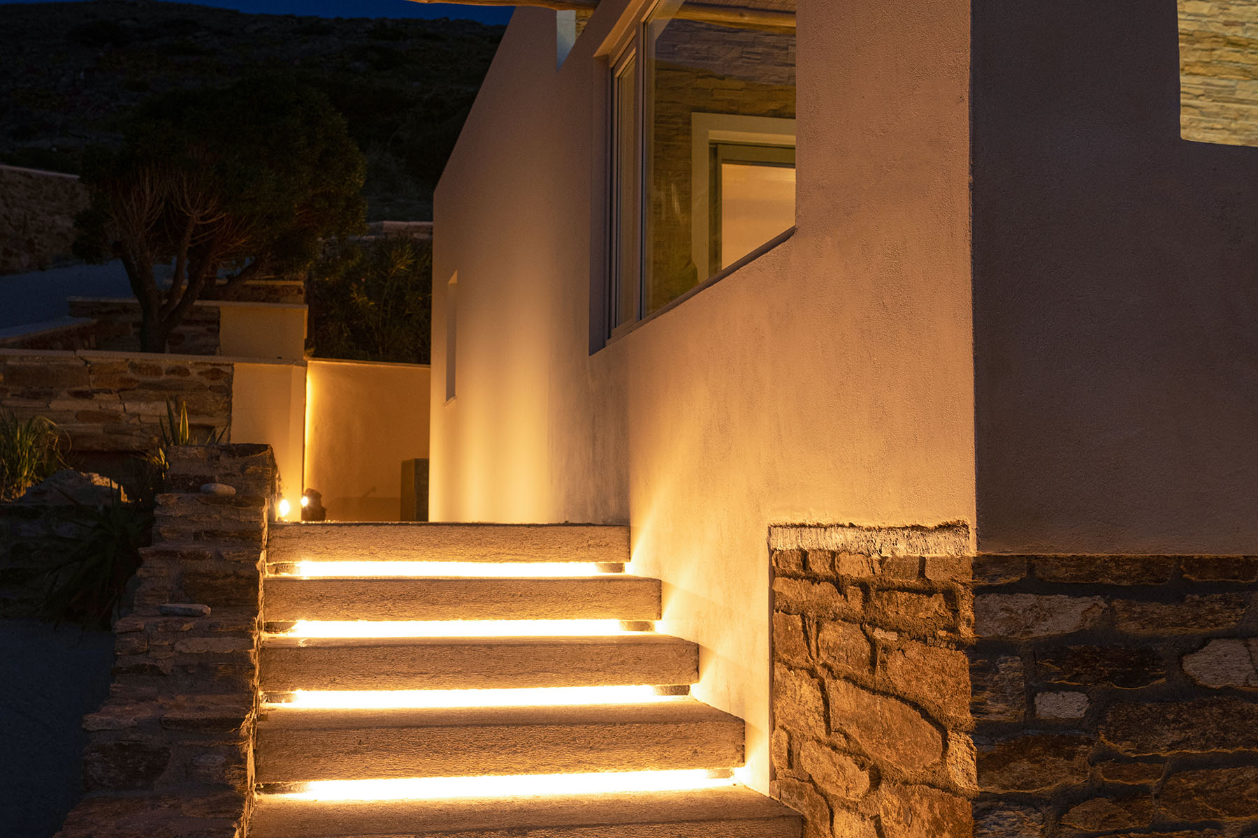 Evening lights on the stone steps of a villa in Ios