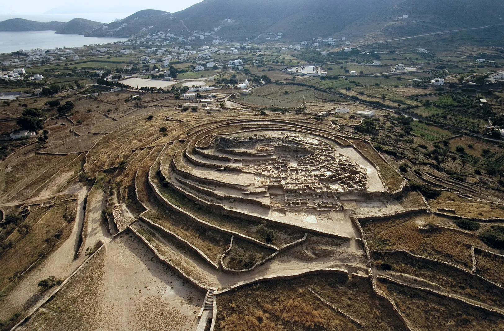 Aerial view of the Skarkos archaeological site on Ios with the sea in the background